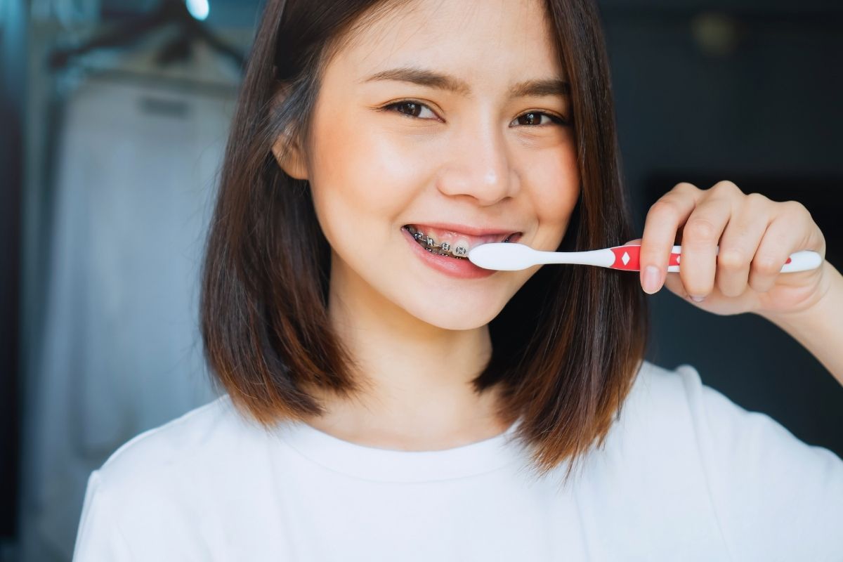 Girl with braces brushing teeth
